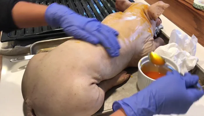 Untar el lechón con aceite Chetta. Revisar si hay pelos que no se hayan quitado.