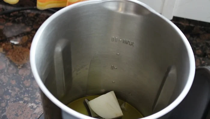 En el vaso de la Mambo con las cuchillas, poner el aceite de oliva y la cebolla. Picar con dos golpes de turbo (1-2 segundos cada uno).