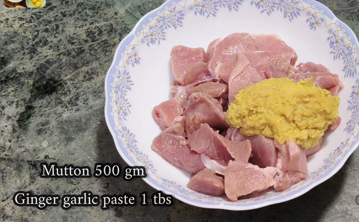 Lavar bien el cordero y añadirlo a un bol. Agregar pasta de jengibre y ajo, cúrcuma, sal, pimienta roja, cilantro, comino y cuajada. Si se usa polvo de masala de cordero, omitir cilantro y comino.