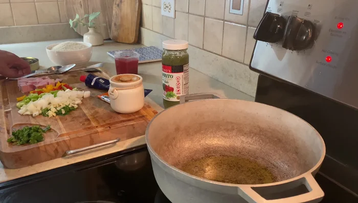 En el caldero, calentar aceite de oliva y sofreír el ajo, la cebolla y los pimientos hasta que estén tiernos.