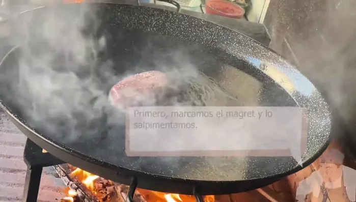 Marcar el magret de pato salpimentándolo y dorarlo en la paella humeante por ambos lados.