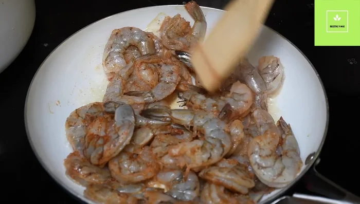 Agregar los camarones a la sartén y cocinar a fuego alto hasta que estén rosados.