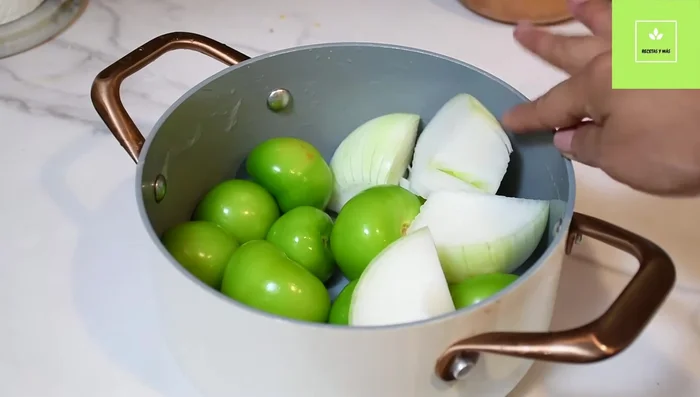 Licuar los tomatillos (o jitomates) con cebolla, ajo, hojas de laurel y chiles guajillo sin semillas, media cucharadita de sal y dos tazas de agua.