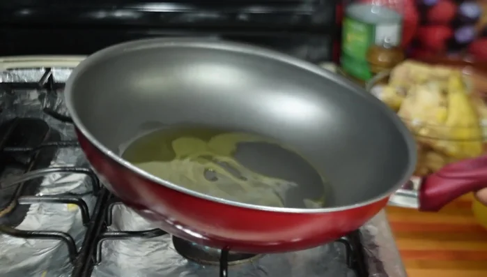 Dorar el pollo poco a poco en el aceite caliente, volteándolo para que se dore por ambos lados.