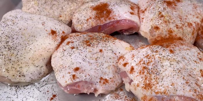 Sazonar las piezas de pollo con aceite, sal, pimienta negra, pimentón dulce y paprika ahumada. Sellarlas rápidamente en una sartén para darles color.