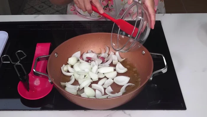 En el aceite restante, pochar la cebolla y los ajos con piel durante 7-10 minutos (161.68).