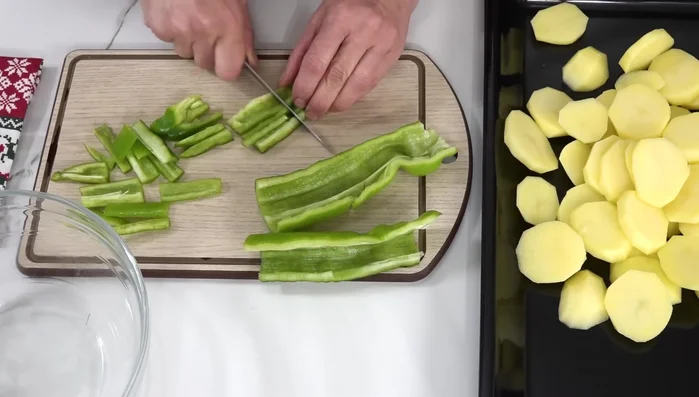 Cortar el pimiento verde en tiras y luego en bastoncitos. Añadirlo a la bandeja.