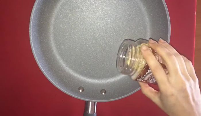 Tostar los piñones en una sartén hasta que estén dorados.