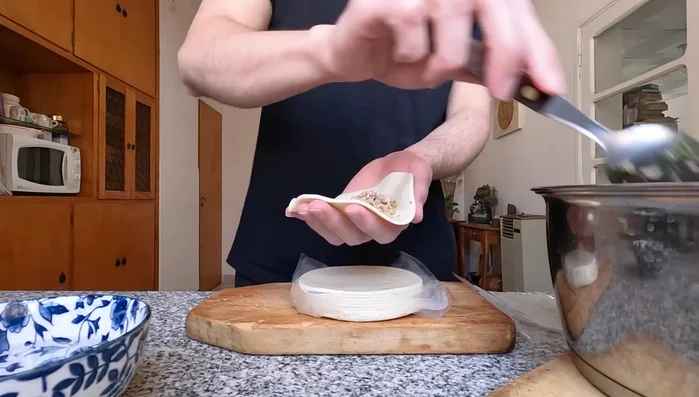 Agregar una cucharada del relleno de carne en el centro del disco de empanada. (135.36)