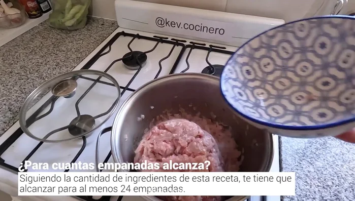 Agregar 1 kg de carne picada de cerdo a la olla. Desmenuzarla un poco con la cuchara para que se cocine de manera pareja. (38.879)