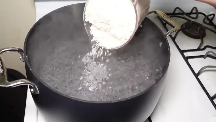 En una olla con agua hirviendo, agregar el arroz y la canela. No revolver.