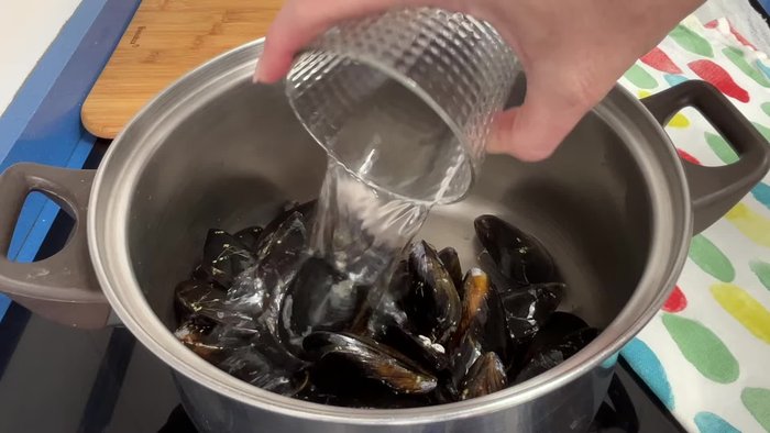 Limpiar los mejillones y cocinarlos en una cacerola con agua y laurel a fuego fuerte durante 2-3 minutos hasta que se abran.