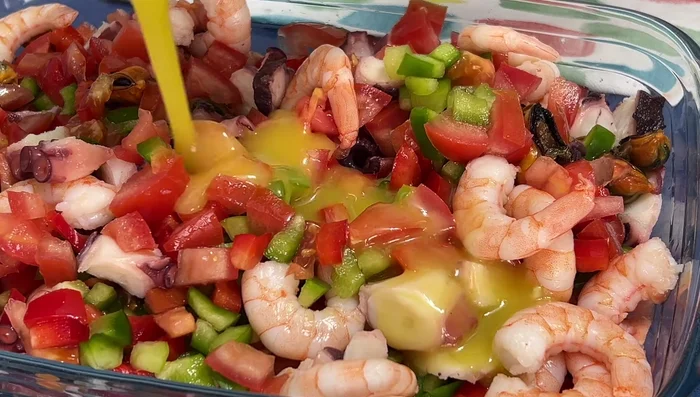 Añadir la vinagreta al salpicón de marisco.