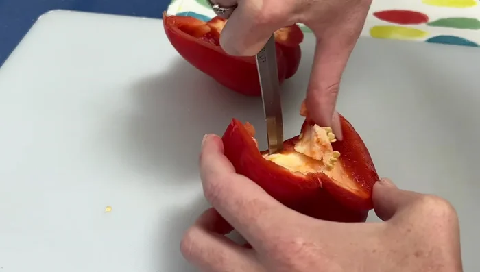 Preparar los pimientos: quitarles el pedúnculo y los nervios, lavarlos y cortarlos en trozos del tamaño deseado.