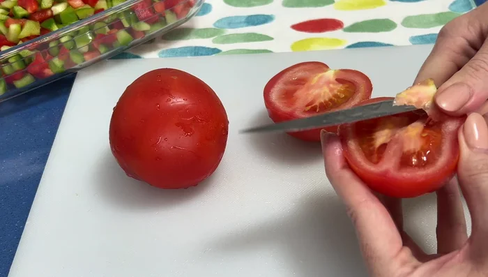 Cortar los tomates por la mitad, quitarles la parte dura del centro y trocearlos.