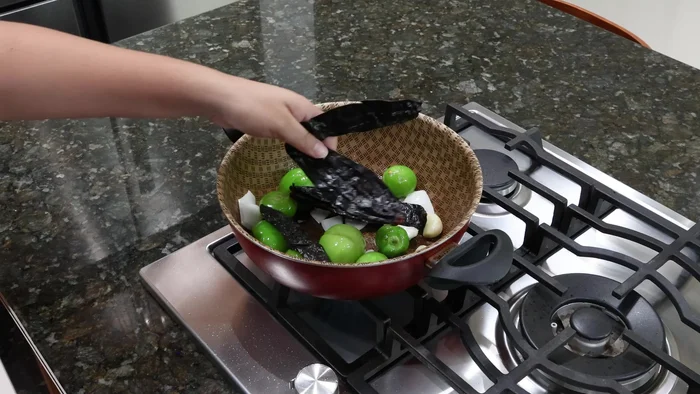 Incorporar los chiles pasilla (sin venas ni semillas) y los chiles de árbol. Mezclar hasta dorar.