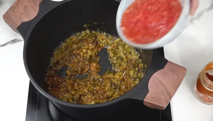Añadir el tomate rallado y cocinar hasta que el tomate se haya reducido.