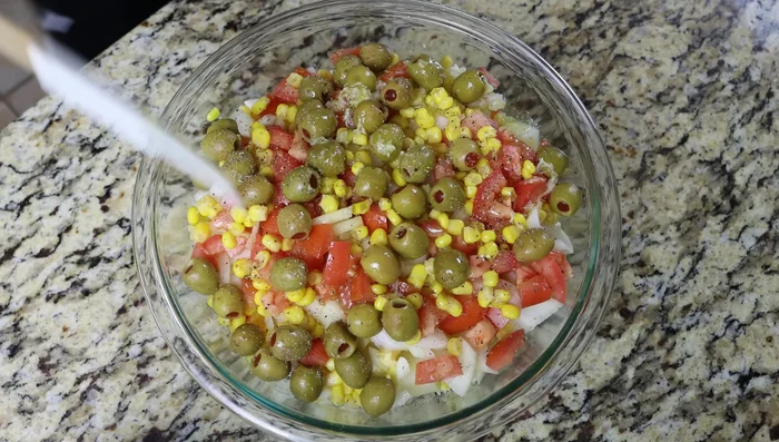 Verter el aderezo sobre la ensalada de patatas y mezclar suavemente.