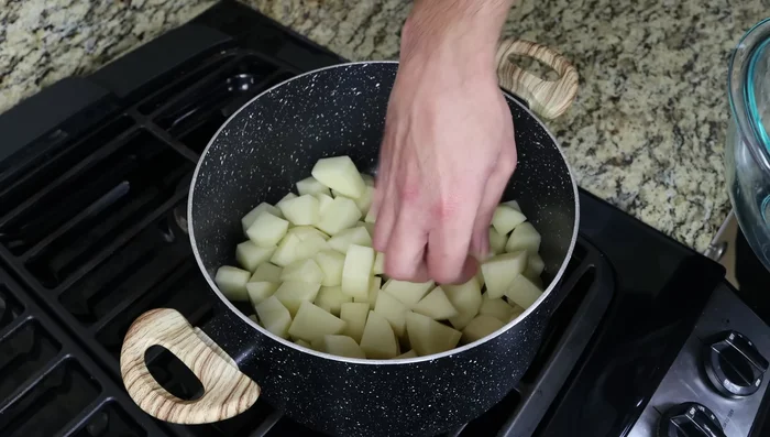 Colocar las patatas en una olla en una capa plana, cubrir con agua apenas hasta cubrirlas, sazonar con sal marina y llevar a ebullición a fuego alto.