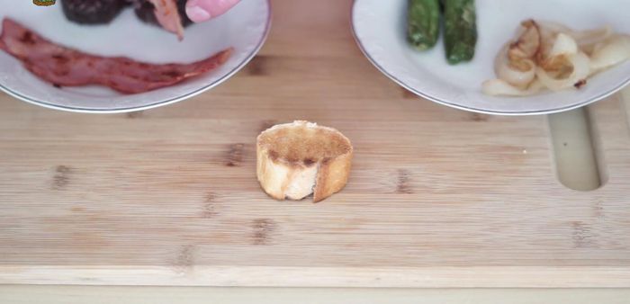 Montar los pinchos: colocar una loncha de beicon doblada sobre el pan tostado, encima la rodaja de morcilla, luego los aros de cebolla y finalmente un pimiento de Padrón. (199.65)
