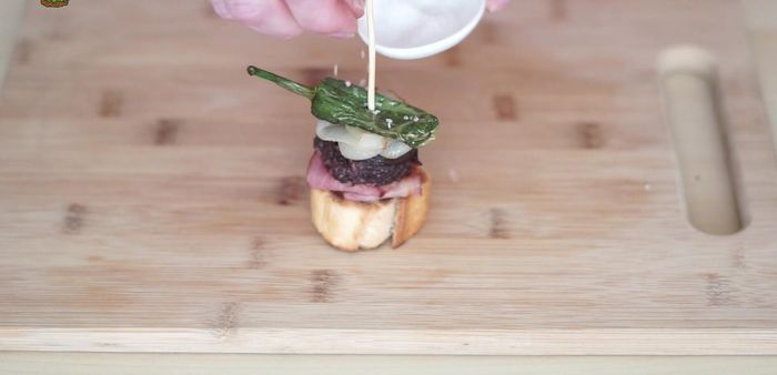 Clavar una brocheta de madera en el pincho para sujetarlo y espolvorear con sal en escamas. (235.11)