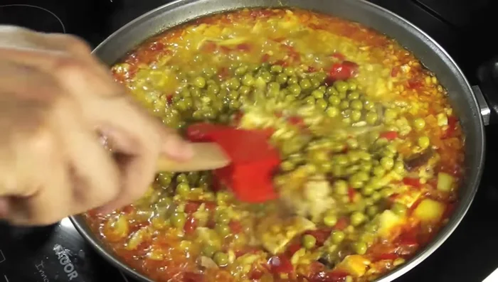 Tras 10 minutos de cocción del arroz, añadir los guisantes y remover.
