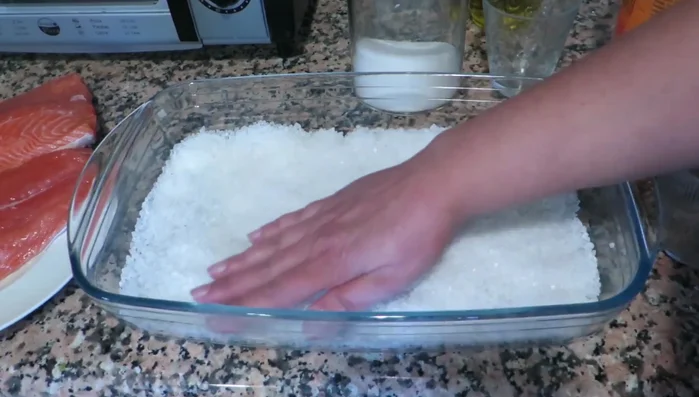 Prepara una cama de sal con un poco de azúcar en una fuente. Aplanar ligeramente.