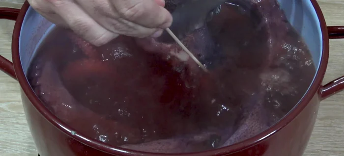 Comprobar la cocción pinchando con un palo de brocheta en la parte más cercana a la cabeza. Si entra y sale fácilmente, el pulpo está listo. Si no, dejar cocer unos minutos más.