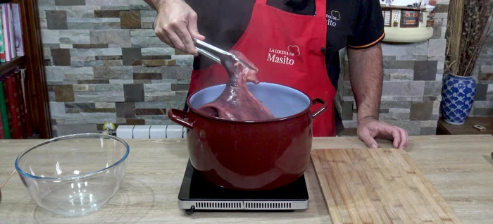 Sacar el pulpo y enfriarlo con agua fría durante 10-15 minutos, colocándolo boca abajo sobre un cuenco.