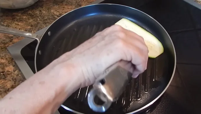 Cocina el pollo y la calabaza a la plancha: Calienta la plancha con un poco de aceite en spray. Asa las calabazas y las pechugas de pollo marinadas, volteándolas para que se cocinen uniformemente. (213.109)