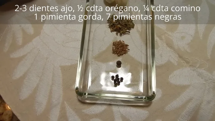 Prepara el marinado: En un molcajete, machaca 2-3 ajos con sal hasta obtener una pasta fina. Agrega orégano, comino, pimienta gorda y negra, machaca y mezcla. Incorpora el jugo de limón y un chorrito de aceite para emulsionar.