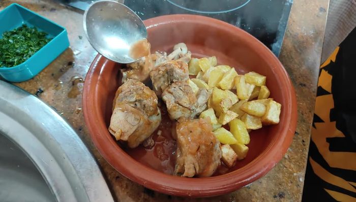 Apagar el fuego y servir el conejo con patatas cortadas en dados pequeños y perejil picado por encima (opcional).