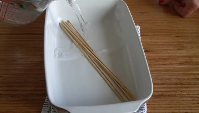 Remojar las brochetas de madera en agua para que no se quemen.