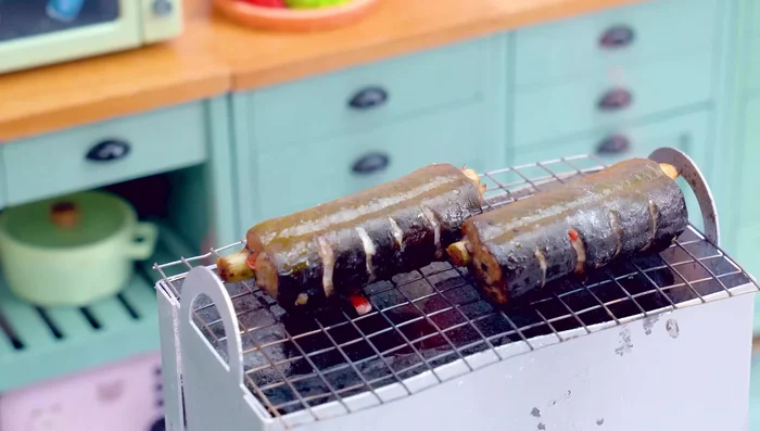 Asar la anguila: Asar la anguila a la parrilla, dándole la vuelta y untándola con aceite de sésamo.