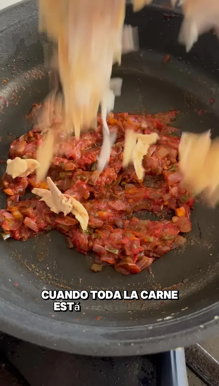 Añadir la carne desmenuzada al sofrito. (53.399 - 56.92)