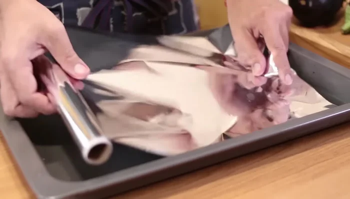 Precalentar el horno a 200°C. Colocar las berenjenas enteras sobre una bandeja de horno con papel para hornear (opcional). Añadir los dientes de ajo.
